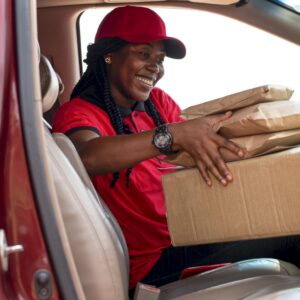 Une femme livreuse qui dépose des colis dans sa voiture